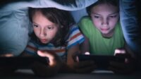 Anak Kecil Sedang Menggunakan Ponsel Di Ruang Tamu