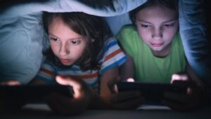 Anak Kecil Sedang Menggunakan Ponsel Di Ruang Tamu