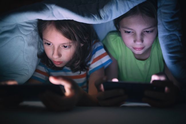 Anak Kecil Sedang Menggunakan Ponsel Di Ruang Tamu