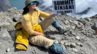 Atiek Cb Berpose Di Puncak Gunung Rinjani Dengan Pakaian Mendaki Warna Kuning Cerah