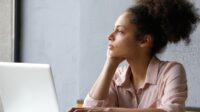 Wanita Duduk Di Depan Laptop Sambil Melamun Dengan Tatapan Kosong